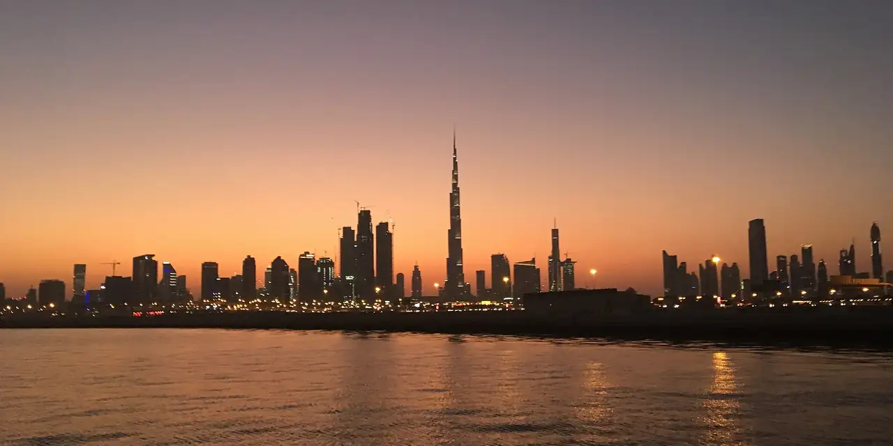 Dubai skyline and the Burj Khalifa at sunset across the water